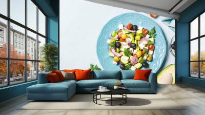 Avocado olives greek salad on blue plate. Top view, space for text. Wall mural