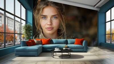 A beautiful girl soldier with blue eyes in a military uniform, full of determination and courage, in the background there is military equipment and field conditions. Copy space Wall mural