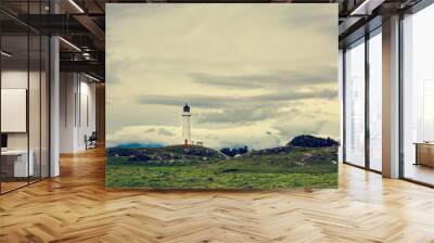 Retro-style photo of Cape Egmont Lighthouse with Mount Taranaki in the background. Gloomy winter day in Taranaki, New Zealand Wall mural