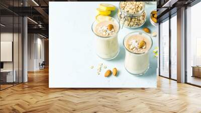 Banana ginger cinnamon almond smoothie with coconut flakes. Selective focus, space for text. Wall mural