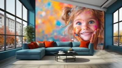 Beautiful cheerful little girl with her face and hands painted in Indian dry powder for the holiday of Holly. Celebrating the Indian festival Holli, national traditions Wall mural