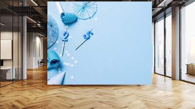 Birthday paper caps with candles and straws on blue background Wall mural