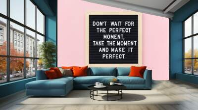 Don't wait for the perfect moment, take the moment and make it perfect. Motivational quote on black letter board frame on pink background. Concept inspirational quote of the day. Wall mural