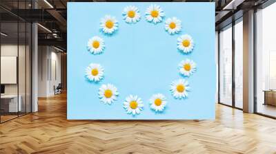 Flower composition. Frame floral round wreath of flowers chamomile on blue background. Template for your design Top view Flat Lay Copy space Wall mural