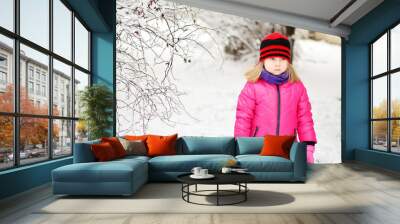 Upset little girl in beautiful winter park during snowfall Wall mural