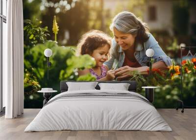 Grandmother with grandaughter gardening in the backyard garden. Wall mural