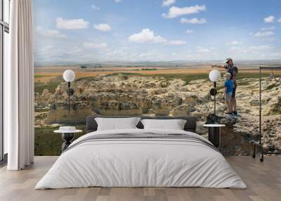 father and son stand on the rock and look at the horizon line. castle rock badlands. western kansas, Wall mural