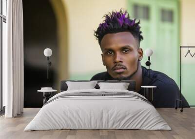 A young African-American man in his early 20s with neon purple hair styled in a high fade, wearing a black t-shirt, confidently gazing into the camera against a light green background Wall mural