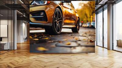 Car on asphalt road on autumn day in countryside. Colored leaves lying under the wheels of the vehicle.  Travel concept. Road trip Wall mural