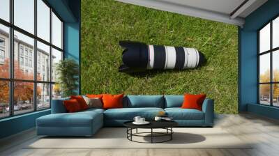 professional camera lens on the green grass Wall mural