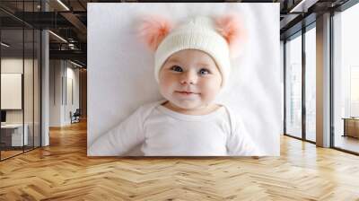 cute adorable baby child with warm white and pink hat with cute bobbles Wall mural