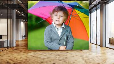 Little cute toddler boy with colorful umbrella and boots, outdoo Wall mural