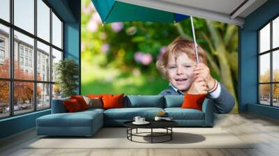 Little cute toddler boy with colorful umbrella and boots, outdoo Wall mural