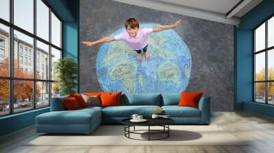 Little school boy with earth globe painting with colorful chalks on ground. Positive kid child. Happy earth day concept. Creation of children for saving world, environment and ecology. Wall mural