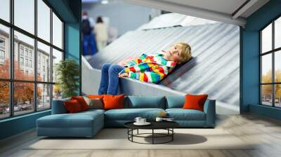 little tired kid boy at the airport, traveling Wall mural