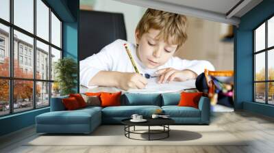 Tired little kid boy at home making homework at the morning before the school starts. Little child doing excercise, indoors. Elementary school and education. Wall mural