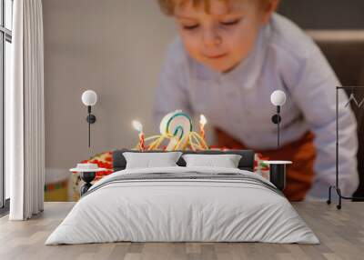 toddler boy blowing candles on his 2 birthday cake Wall mural