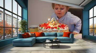 toddler child blowing candles on his 2 birthday cake Wall mural