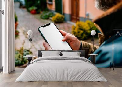 Close-up of blank mockup smartphone screen in man's hands on street background, lifestyle mobile app template Wall mural