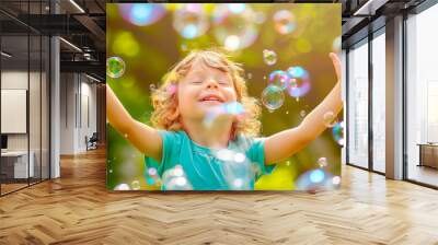 Portrait of a little happy child rejoicing with soap bubbles on a sunny meadow. Active children's summer holiday concept Wall mural