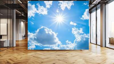 Shining sun through fluffy clouds on blue clean sky background Wall mural