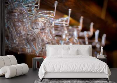 Clean washed glasses hanging over a bar rack Wall mural