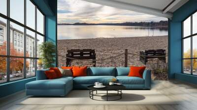 Two empty wooden lounge benches by the lake. Wall mural