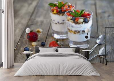 Two glasses of strawberry parfait made from fresh fruit, yogurt, blueberries, flax seeds and muesli on a wooden background. Healthy Eating Concept Wall mural