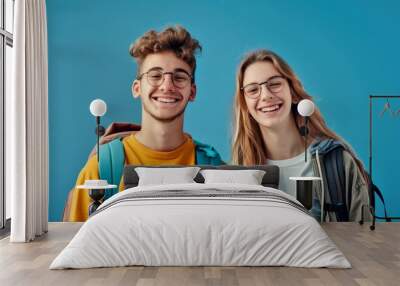 Happy young friends posing against blue background. Two students with backpacks and wearing glasses smiling. Casual style, vibrant colors, perfect for educational and youth-themed stock photos. AI Wall mural