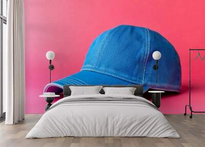 This image showcases a stylish blue cap against a vibrant pink background. The cap features a classic design and bright color, perfect for casual wear or fashion. AI Wall mural