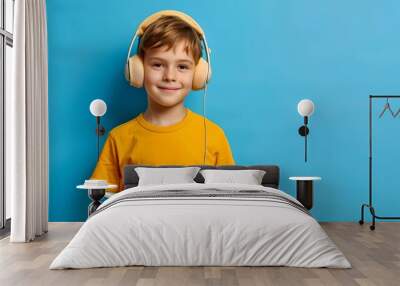 Young boy in yellow shirt enjoys reading and listening to music. Cheerful kid with book and headphones against blue background. Educational and leisure concept for children. AI Wall mural