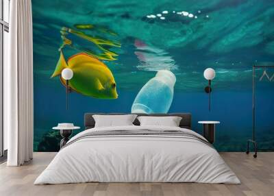 Underwater view with goldfish and garbage plastic bottle in the water. Plastic pollution. Save nature. Stop ocean plastic contamination. Environmental ocean pollution. Wall mural