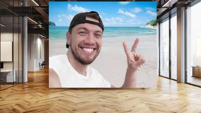 Young handsome guy making selfie on the beach Wall mural