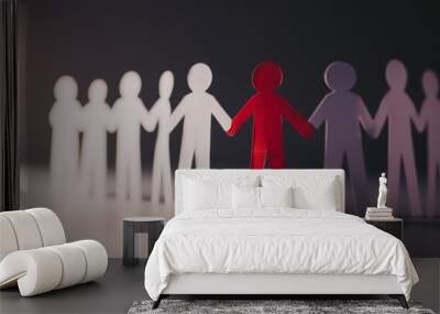 Red figure standing out among white paper people cutouts Wall mural