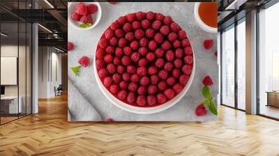 No baked raspberry cheesecake or raspberry cream mousse cake with jelly and fresh berries on top on a white plate on a gray concrete background. Summer cake. Wall mural