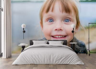 Funny little baby girl posing near lake. Closeup Wall mural