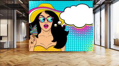 Wow female face. Sexy surprised girl in hat and sunglasses with open mouth holding bright ice cream in her hand and speech bubble on halftone. Vector summer background in pop art retro comic style. Wall mural