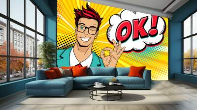 Wow pop art male face. Young handsome man in glasses smiles, winks and shows okay sign and OK! speech bubble. Vector illustration in retro comic style. Vector pop art background. Invitation poster. Wall mural