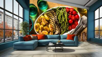 a side dish of vegetables on the holiday table. healthy food for the whole family or dinner at a restaurant on a wooden table. baked potatoes, grilled eggplants, cherry tomato salad  Wall mural