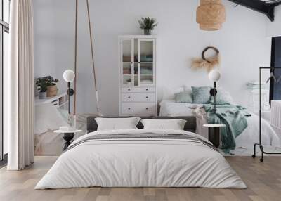 Modern scandinavian sunny bedroom with plants , white bedding and pillows. Space with white walls and wide window. Eco decor. Real photo. Wall mural