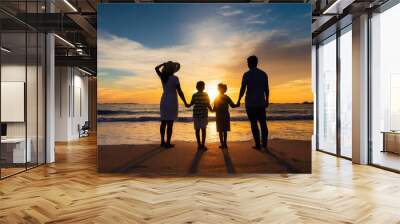 Family holding hands with father, mother and two children watching sunset on beach Wall mural