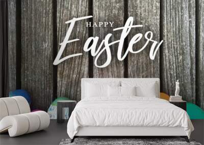 Happy Easter Calligraphy Text Message with Colorful Decorated Eggs Over Rustic Wooden Background Wall mural