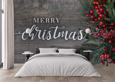 Merry Christmas Text with Evergreen Branches and Berries Over Rustic Dark Wood Horizontal Background Wall mural