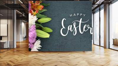 Spring season still life with Happy Easter calligraphy holiday script over dark blackboard background texture with beautiful colorful white, pink, orange, purple and green flower blossom bouquet Wall mural