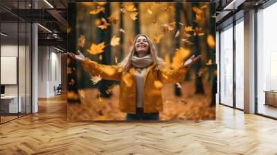 Autumn happy mood, positive emotions as a remedy for autumn depression. Autumn photo of happy beautiful girl with curly hair throws autumn leaves in fall park. Wall mural