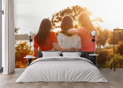 Summer Camp, Summer Classes, Friends University. Three cheerful girls friends dance and jump on summer sunset nature background. Group of friends on summer vacations Wall mural