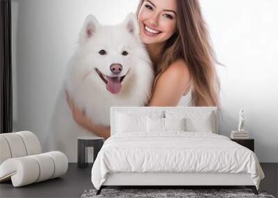 Beautiful woman is sitting and hugging her white fluffy dog while smiling on a isolated white background Wall mural