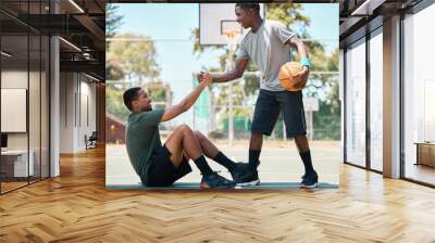 Basketball, sports and teamwork, helping hand and support, respect and assistance in competition training games. Happy basketball player holding hands with friend, trust and kindness on outdoor court Wall mural