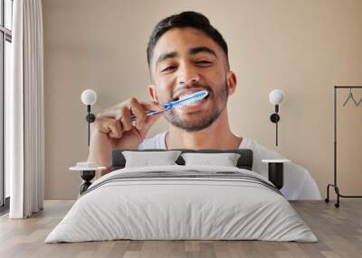 Getting my smile ready. Studio shot of a handsome young man brushing his teeth against a studio background. Wall mural