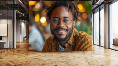 Attractive black man portrait. Student is working in cafe, learning, looking to camera and smile Wall mural